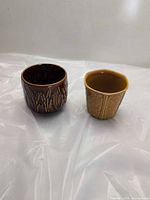 Two small pottery planters side by side