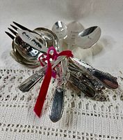 Bundle of all twelve silverplate utensils tied with ribbon