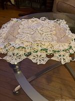 Stack of crocheted doilies on glass table