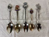 All five commemorative spoons laid out front view