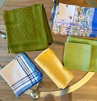 Five stacks of napkins in various colours on table