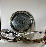 Stack of silver plated trays and chargers showing variety and quantity