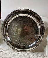 Full view of round silver-plated tray showing border and engraving