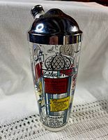 Front view of the Hazel Atlas glass cocktail shaker showing Paris motif graphics, recipe panels, chrome cap and pour spout