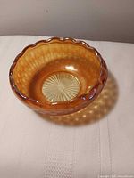 Top view showing amber color, scalloped rim and interior sunburst base pattern
