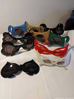 All eight novelty sunglasses arranged on table displaying frame colours and shapes