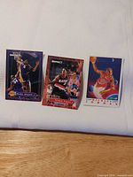 Overview of all three trading cards laid on white cloth