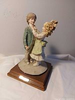 Full view of porcelain figurine on wood base