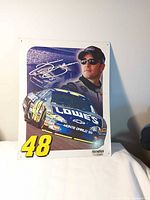 Full view of metal sign showing driver portrait, race car, number 48