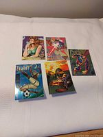 Five trading cards laid out on a white surface