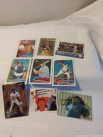 Group shot of nine baseball cards laid out on white surface