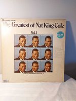Front cover of Volume 1 LP showing grid of Nat King Cole portraits and pricing sticker