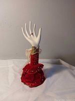 Front view of hand jewelry holder with red ruffled base