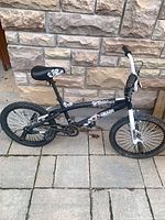 Right side view of 20" BMX bicycle showing frame graphics, saddle and rear wheel