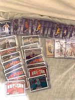 Overview of all sleeved Panini NBA Hoops cards laid out on fabric surface