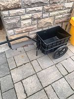 Full view of black plastic tub garden cart attached to metal frame with pull handle and wheels