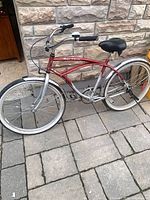 Full left side view of red/silver Schwinn step-through cruiser bicycle