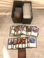 Two black storage boxes filled with Flesh and Blood cards, several cards spread out for view