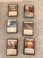 Six shrink-wrapped stacks of Uprising token and equipment cards, top cards identified