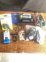 All items laid out including phone case, pump, bell, mount, lights, cords, screws