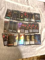 Group overview of all foil token cards spread on cloth surface
