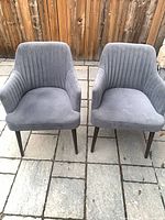 Two matching gray velvet armchairs front view