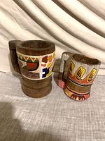Front view of both painted wooden mugs