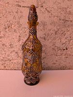 Full view of amber glass decanter with pewter overlay and stopper