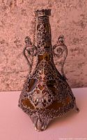 Front view of amber decanter showing pewter filigree overlay and double-headed eagle motif