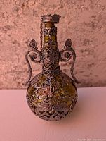 Front view showing pewter filigree, handles and stopper
