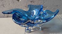 Oblique view showing freeform folds, cobalt and aqua layers, clear foot