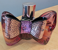 Front view showing sequin fabric bow, color gradient glass, cap