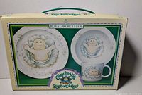 front view of boxed dish set showing plate, bowl and mug graphics