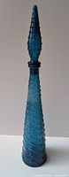 Full view of assembled blue wavy glass decanter with hobnail stopper
