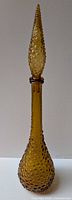 Full view of glass genie bottle with stopper attached