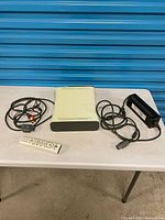 Console, power supply, AV cable, remote on table