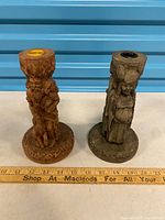 Both carved candle holders side by side with ruler showing height