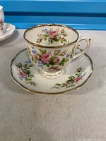 Teacup and saucer front showing floral design and gold trim