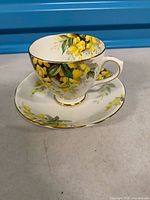 Teacup on saucer showing floral pattern and gold trim