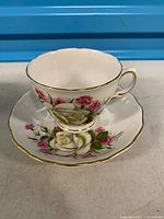 teacup placed on saucer showing floral pattern and gold trim