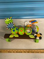 Front view of caterpillar activity panel showing mirror, rattle, teether and attachments