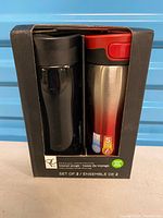 Front view of retail box showing both travel mugs