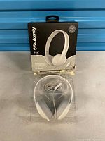 Headphones in plastic tray with damaged original box behind