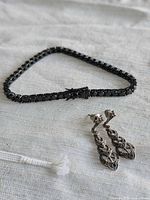 Bracelet arranged in triangle, earrings and clasp detail visible