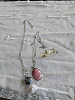 Overview of both necklaces and pair of earrings
