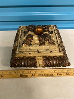 top view of square baroque style trinket box showing finial and ornate relief