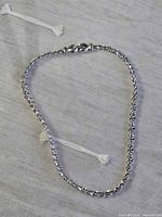 Full view of silver-tone link necklace arranged in oval showing clasp