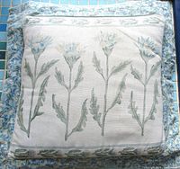 Full view of square pillow showing thistle design and border