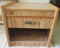 Front view showing drawer with brass pull and shelf