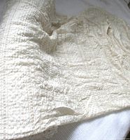 Folded ivory embossed lace mesh fabric showing texture